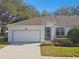 Exterior view of house with white garage door and landscaping at 8529 Alexandra Arbor Ln, Temple Terrace, FL 33637