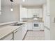 White kitchen with stainless steel sink and built-in microwave at 8529 Alexandra Arbor Ln, Temple Terrace, FL 33637