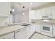Clean kitchen boasts white cabinets and a double sink at 8529 Alexandra Arbor Ln, Temple Terrace, FL 33637