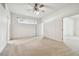 Main bedroom with ceiling fan, carpet, and access to other rooms at 8529 Alexandra Arbor Ln, Temple Terrace, FL 33637