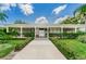 Community building exterior with a covered walkway and manicured hedges at 4140 55Th N St # 1211, Kenneth City, FL 33709