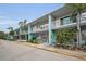 Wide shot of a teal condo building with palm trees and a parking lot at 4140 55Th N St # 1211, Kenneth City, FL 33709