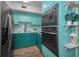 Teal kitchen with stainless steel appliances and wood-look flooring at 4140 55Th N St # 1211, Kenneth City, FL 33709