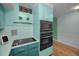 Modern kitchen with teal cabinets, updated appliances, and wood flooring at 4140 55Th N St # 1211, Kenneth City, FL 33709