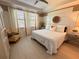 Spacious bedroom with a large bed, light wood floors, and a cozy chair at 10059 Crooked Creek Dr # 102, Venice, FL 34293