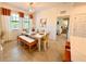 Bright dining room with a white table, woven bench, and yellow chairs at 10059 Crooked Creek Dr # 102, Venice, FL 34293