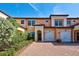 Tan two-story townhome with two-car garage and landscaped front at 10059 Crooked Creek Dr # 102, Venice, FL 34293