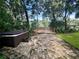 Relaxing hot tub on a brick patio with a deck and lush landscaping at 11554 Monette Rd, Riverview, FL 33569