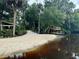 Sandy riverbank with private dock and lush vegetation at 11554 Monette Rd, Riverview, FL 33569