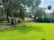 Large grassy yard with stone retaining wall and detached building at 11554 Monette Rd, Riverview, FL 33569