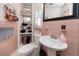 Retro bathroom with pink tile, pedestal sink, and built-in shelving at 121 Live Oak Ln, Largo, FL 33770