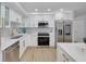 Modern white kitchen with stainless steel appliances and gold accents at 1448 S Hercules Ave, Clearwater, FL 33764