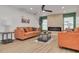 Cozy living room with orange couches, a modern fireplace, and light wood floors at 1448 S Hercules Ave, Clearwater, FL 33764
