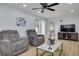 Living room with grey recliner chairs, a coffee table, and a large TV at 1448 S Hercules Ave, Clearwater, FL 33764