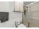 Bright bathroom with toilet, shower, and overhead cabinets at 14912 Brookridge Blvd, Brooksville, FL 34613