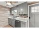 Modern kitchen with gray cabinets, white countertops, and wood-look vinyl flooring at 14912 Brookridge Blvd, Brooksville, FL 34613
