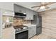 Modern kitchen with gray cabinets, stainless steel appliances and wood-look floors at 14912 Brookridge Blvd, Brooksville, FL 34613