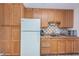 Simple kitchen with wood cabinets and appliances at 1725 Pine Ridge E Way # E, Palm Harbor, FL 34684