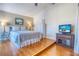 Main bedroom with a queen-size bed and wood floors at 175 Medallion Blvd # F, Madeira Beach, FL 33708