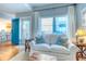 Living room with blue door, hardwood floors, and a comfy white couch at 175 Medallion Blvd # F, Madeira Beach, FL 33708