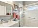 Updated bathroom with a walk-in shower, gray vanity, and large mirror at 18520 Oak Way Dr, Hudson, FL 34667