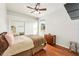 Bright bedroom with a queen-size bed, wood floors, and mirrored closet doors at 18520 Oak Way Dr, Hudson, FL 34667