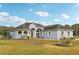 A one-story light blue house with a large front yard and mature trees at 18520 Oak Way Dr, Hudson, FL 34667