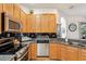 Kitchen with light wood cabinets, granite counters, and stainless steel appliances at 18520 Oak Way Dr, Hudson, FL 34667
