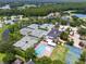 Aerial view showcasing community tennis courts, a pool, and surrounding residential area at 18732 Wimbledon Cir, Lutz, FL 33558