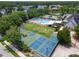 Aerial view of community pool, tennis courts, and basketball courts surrounded by lush landscaping and mature trees at 18732 Wimbledon Cir, Lutz, FL 33558
