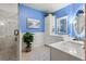 Bright bathroom featuring a double sink vanity and a glass enclosed walk-in shower at 18732 Wimbledon Cir, Lutz, FL 33558