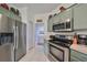 Stainless steel appliances and light green cabinets highlight this kitchen at 2019 Acadia Greens Dr # 34, Sun City Center, FL 33573