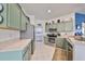 Modern kitchen with stainless steel appliances and light green cabinets at 2019 Acadia Greens Dr # 34, Sun City Center, FL 33573