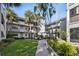 Exterior of condo building with lush landscaping and walkways at 2650 Countryside Blvd # C309, Clearwater, FL 33761