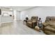Living room with gray walls, wood-look floors, and partial kitchen view at 2650 Countryside Blvd # C309, Clearwater, FL 33761