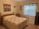 Bedroom with queen bed and window overlooking backyard at 38245 Ironwood Pl # 0, Zephyrhills, FL 33542