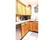 Functional kitchen with wood cabinets, stainless steel dishwasher, and tile floor at 4214 Trucious Pl, New Port Richey, FL 34652