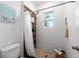 Small bathroom with a shower, toilet, and wood-look walls at 4402 Sailplane Ct, Wesley Chapel, FL 33545