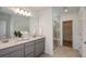 Double vanity bathroom with gray cabinets and a walk-in shower at 5309 Wolf Creek Dr, Apollo Beach, FL 33572