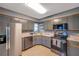 Kitchen boasts stainless steel appliances and gray cabinets at 5567 Sea Forest Dr # 320, New Port Richey, FL 34652