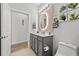 Modern bathroom with gray vanity and round mirror at 5672 Bay Tide Ct, Land O Lakes, FL 34638