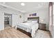 Bright bedroom with a king-size bed, ensuite bathroom access, and wood-look floors at 5672 Bay Tide Ct, Land O Lakes, FL 34638