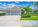 Two-car garage with gray exterior and landscaping at 6429 Seasound Dr, Apollo Beach, FL 33572