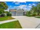 Gray house with three-car garage, landscaping, and a large driveway at 6429 Seasound Dr, Apollo Beach, FL 33572