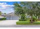 Gray two-car garage home with lush landscaping and a palm tree at 6429 Seasound Dr, Apollo Beach, FL 33572