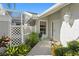 Inviting front entry with white door and lush landscaping at 7710 Palm Aire Ln, Sarasota, FL 34243