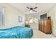 Bright bedroom with teal bedding, ceiling fan, and wood dresser at 10265 Gandy N Blvd # 1715, St Petersburg, FL 33702