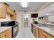 Well-equipped kitchen with black appliances and wood cabinets at 10817 Keys Gate Dr, Riverview, FL 33579