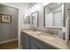 Double vanity bathroom with granite countertops and gray cabinets at 11911 Mandevilla Ct, Tampa, FL 33626
