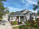 House exterior with gray siding, stone accents, and lush landscaping at 11911 Mandevilla Ct, Tampa, FL 33626